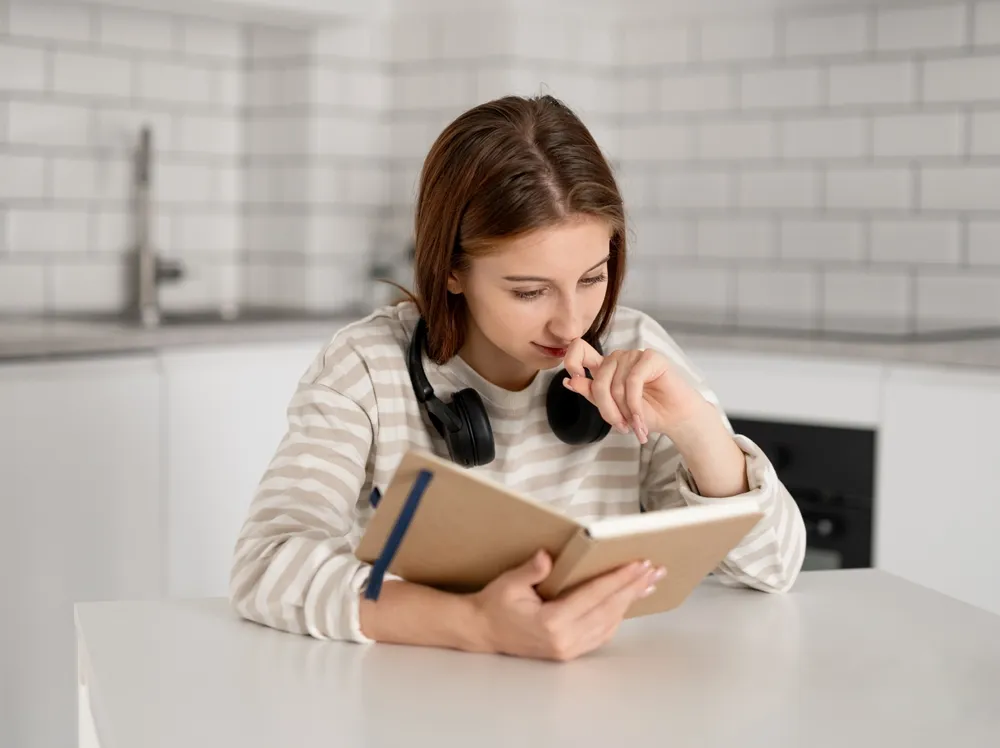 Girl With Interest Reads Notes In Notebook At Home